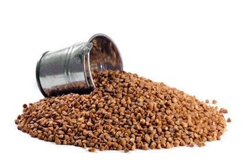 Metal bucket and buckwheat isolated on a white background. Close-up.