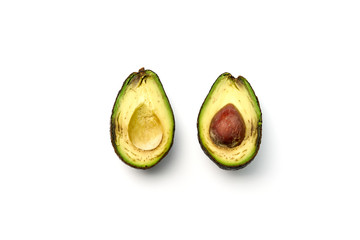 A rotten avocado cut in half on white background.