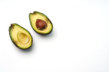 Two slices of avocado isolated on the white background. One slice with core. Copy space, top view.