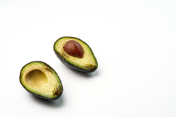 Two slices of avocado isolated on the white background. One slice with core.