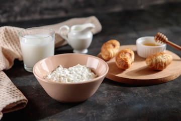 Cottage cheese with a glass of milk and croissants with honey on the table, space for text. Tasty breakfast.