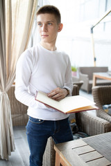 Obraz premium Close up portrait of young man reading menu in a restaurant. Business lunch concept.