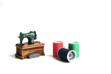 Skeins of thread for needlework and sewing and sewing machine isolated on white background. Tailor still life set
