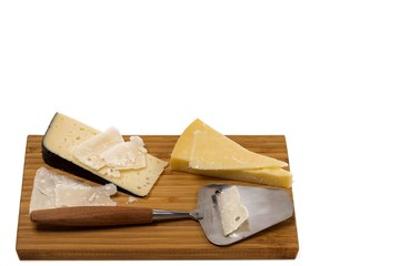 Close up view of different kinds of cheese with cheese knife isolated on wooden board. Healthy food concept.