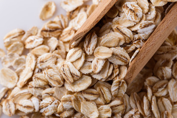 raw oat flakes on white acrylic background