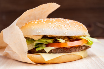 Burger general view from the side on a wooden background.