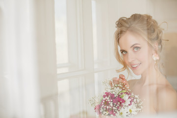 Bride with wedding flowers bouquet. Woman in wedding dress. Young fashion model with perfect skin, make up and Beautiful Hairstyle. Happy day. Marriage.