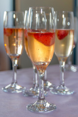 Beautifully decorated welcome drink - a glass of Prosecco or champagne with raspberry inside, served as a welcome drink on a event,