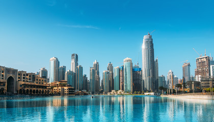 Downtown Dubai district skyline panorama with high rise buildings reflected in pool water. United Arab Emirates, UAE.