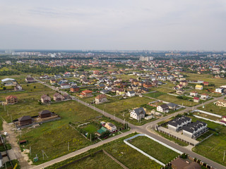 Fototapeta na wymiar Aerial view of the village against the background of the far-sighted city on a summer day