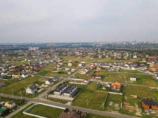 Aerial view of the village against the background of the far-sighted city on a summer day