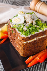 a huge herring sandwich with mayonnaise and quail eggs