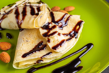 crepes with banana and chocolate spread on a green plate