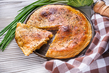 freshly baked cabbage pie on rustic wooden background