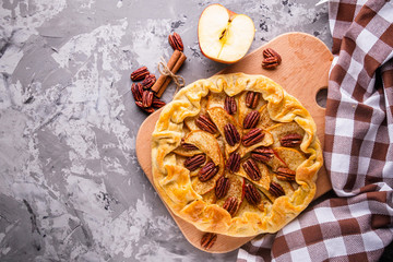 crispy apple galette with pecans on a rustic wooden background
