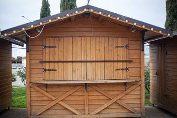 Wooden stalls for selling souvenirs in the park. Tents from boards for street trading. City arrangement of public recreation area.