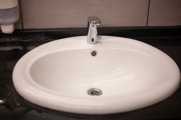 White sink in the mall. Dressing room. Place for washing hands. Cleaning in the bathroom.