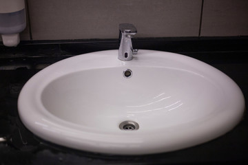 White sink in the mall. Dressing room. Place for washing hands. Cleaning in the bathroom.