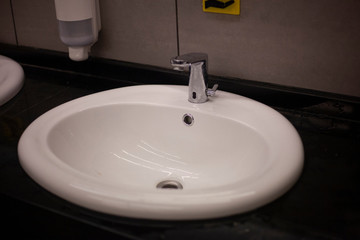 White sink in the mall. Dressing room. Place for washing hands. Cleaning in the bathroom.