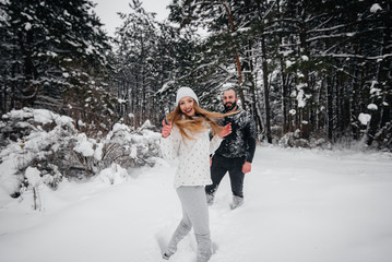 Couple playing with snow in the forest