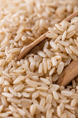 raw brown rice on white acrylic background