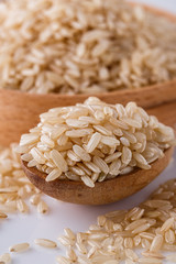 raw brown rice on white acrylic background