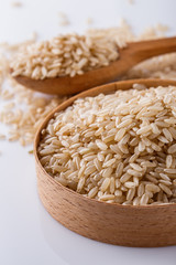 raw brown rice on white acrylic background