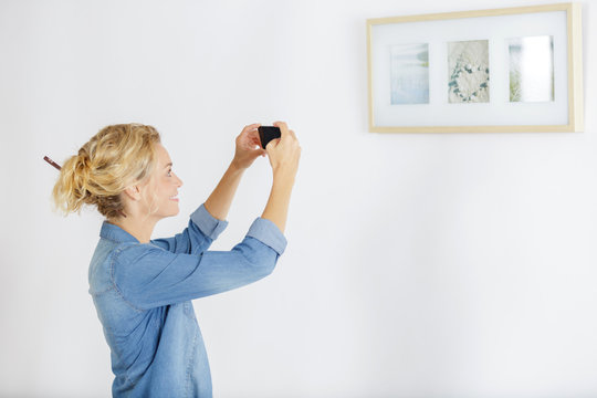 woman takes picture of painting