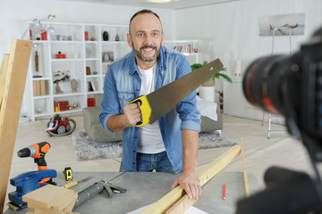 man handsawing in front of the camera