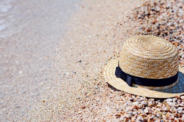 Fototapeta na wymiar Straw hat on sand, sun protection concept. Women's beach accessories or summer outfit on a sandy background.