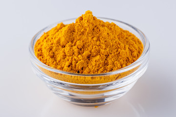 natural turmeric powder on white acrylic background
