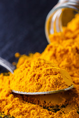 natural turmeric powder on a dark stone background