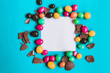 Easter composition with chocolate eggs on a colored blue background, place for text.