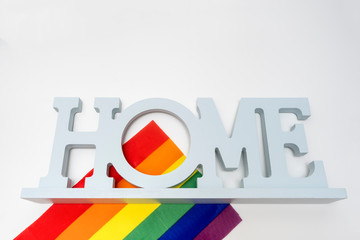 Lgbt rainbow gay pride flag and a sign home on white background