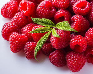 Juicy fresh natural raspberries on white acrylic background
