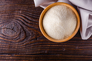 natural organic semolina on dark wooden rustic background