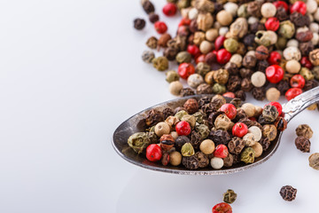 mix of peppercorns on white acrylic background