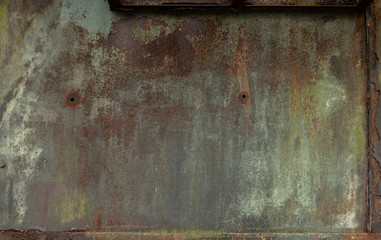 Verwitterte rostige Stahlwand mit grünen und roten Farbtönen