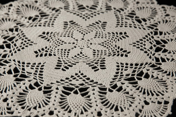 crocheted napkins, white lace on a black background