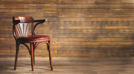 Leather and wood chair on an old wooden background with copy space.