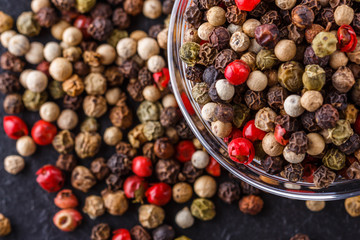 mix of peppercorns on a dark stone background