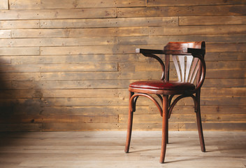 Leather and wood chair on an old wooden background with copy space.