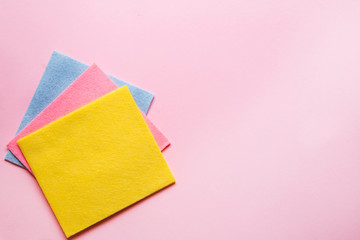 Pastel pink table cleaning background with rag and rubber protective gloves for different surfaces cleaning in kitchen, bathroom and other rooms.