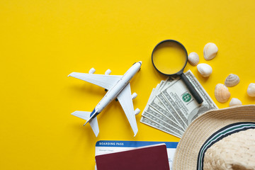 Travel accessories and objects on a yellow background with a top view and copy space. Airplane and...