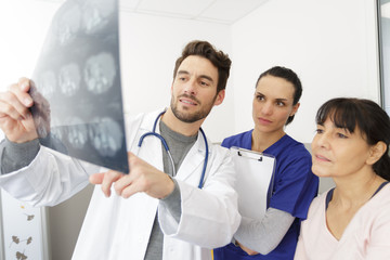 three doctors discussing scan results of x-ray image