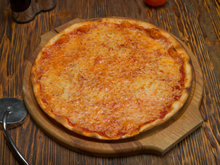 Pizza, tomatoes, cheese, olive oil on a wooden table