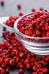 pink peppercorns on a dark stone background