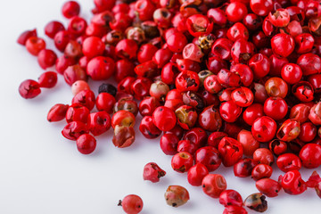 fragrant pink peppercorns on white acrylic background