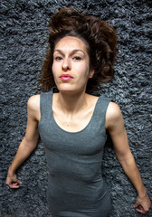 Young woman laying on a grey carpet