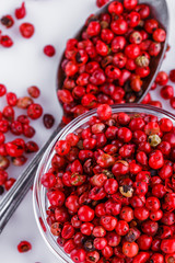 fragrant pink peppercorns on white acrylic background